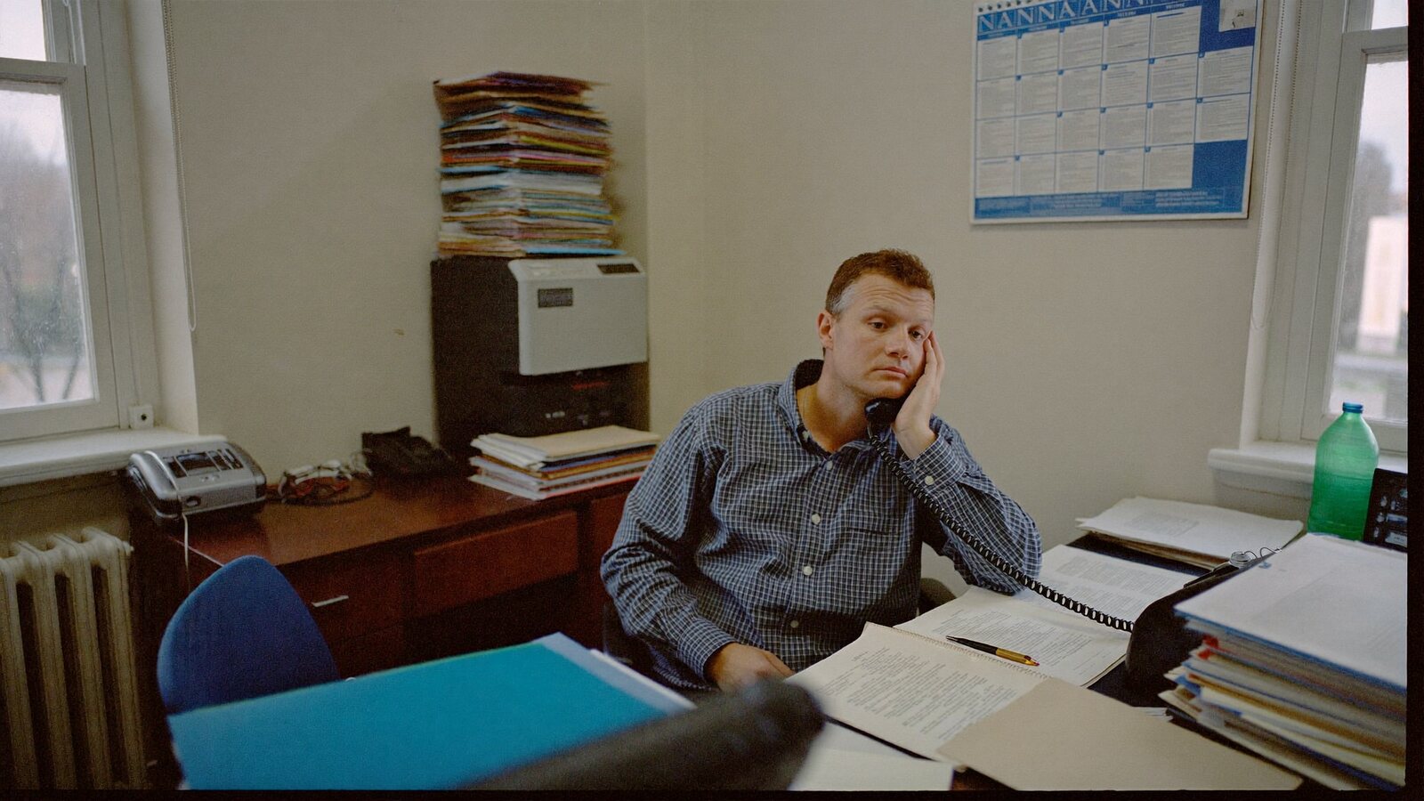 Illustration : un commercial à bout dans son bureau, la tête dans la main devant ses dossiers