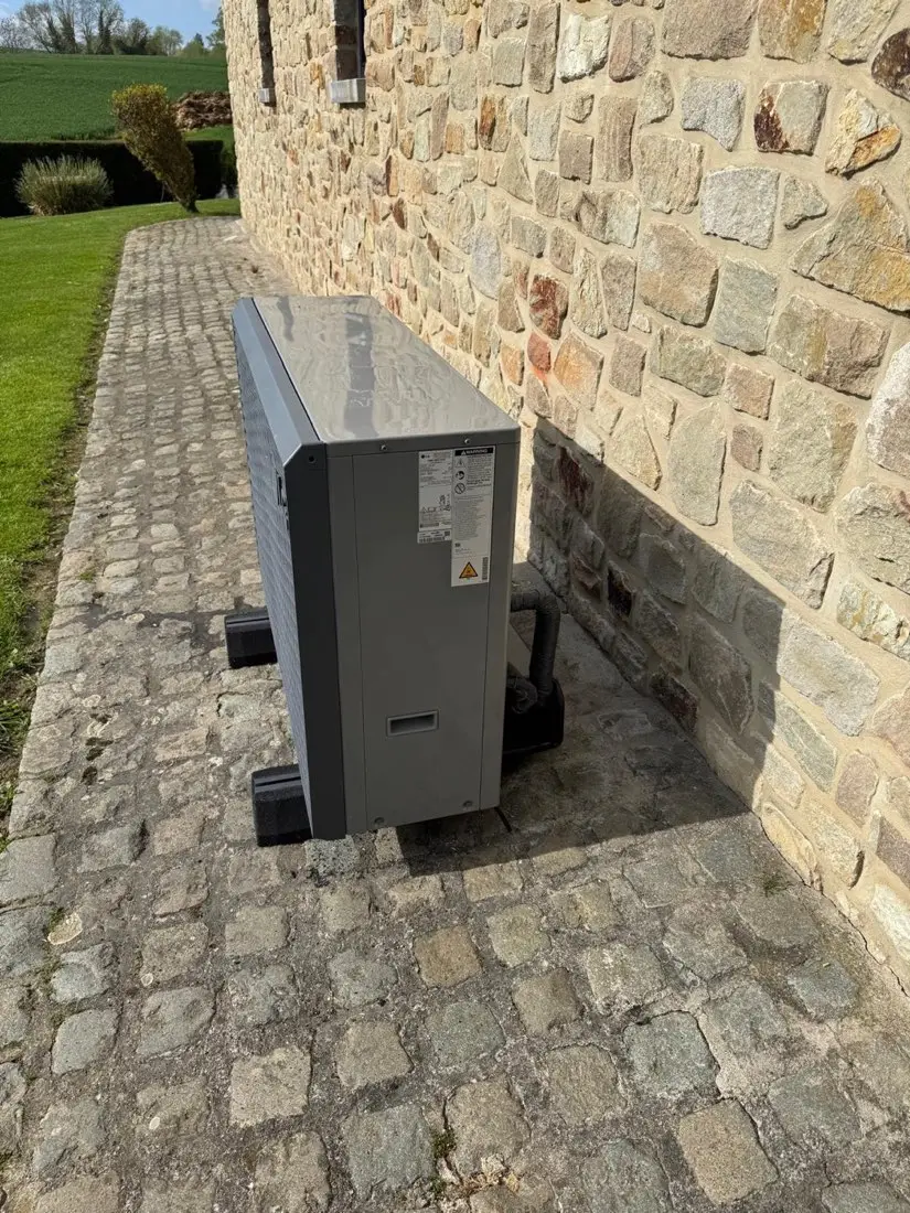 Pompe à chaleur air-eau LG posée par M2B le long d'une maison en pierre