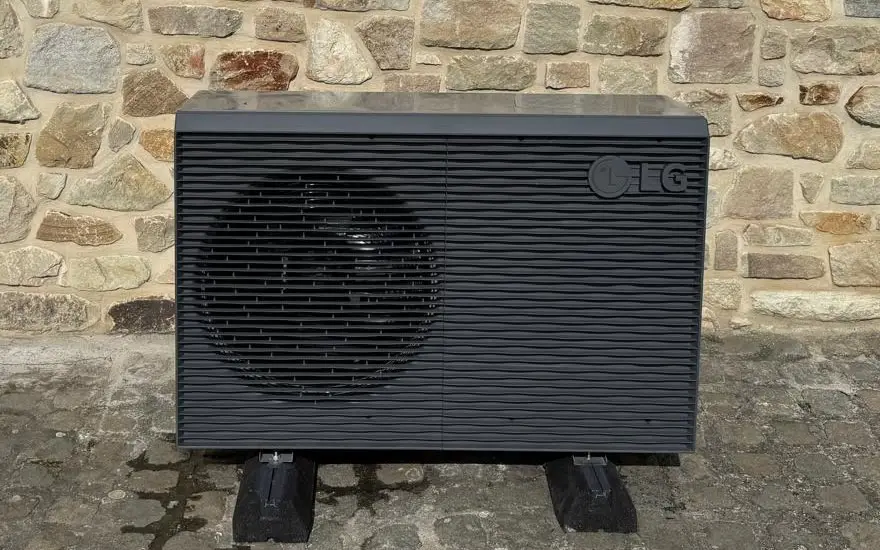 Pompe à chaleur air-eau LG anthracite posée par M2B contre un mur en pierre